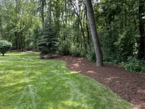 Dark brown mulch application for a well-maintained yard in Wales, WI