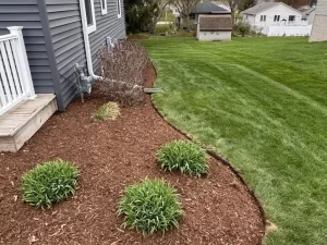 Fresh mulch installation around flower beds at a home in Dousman, WI